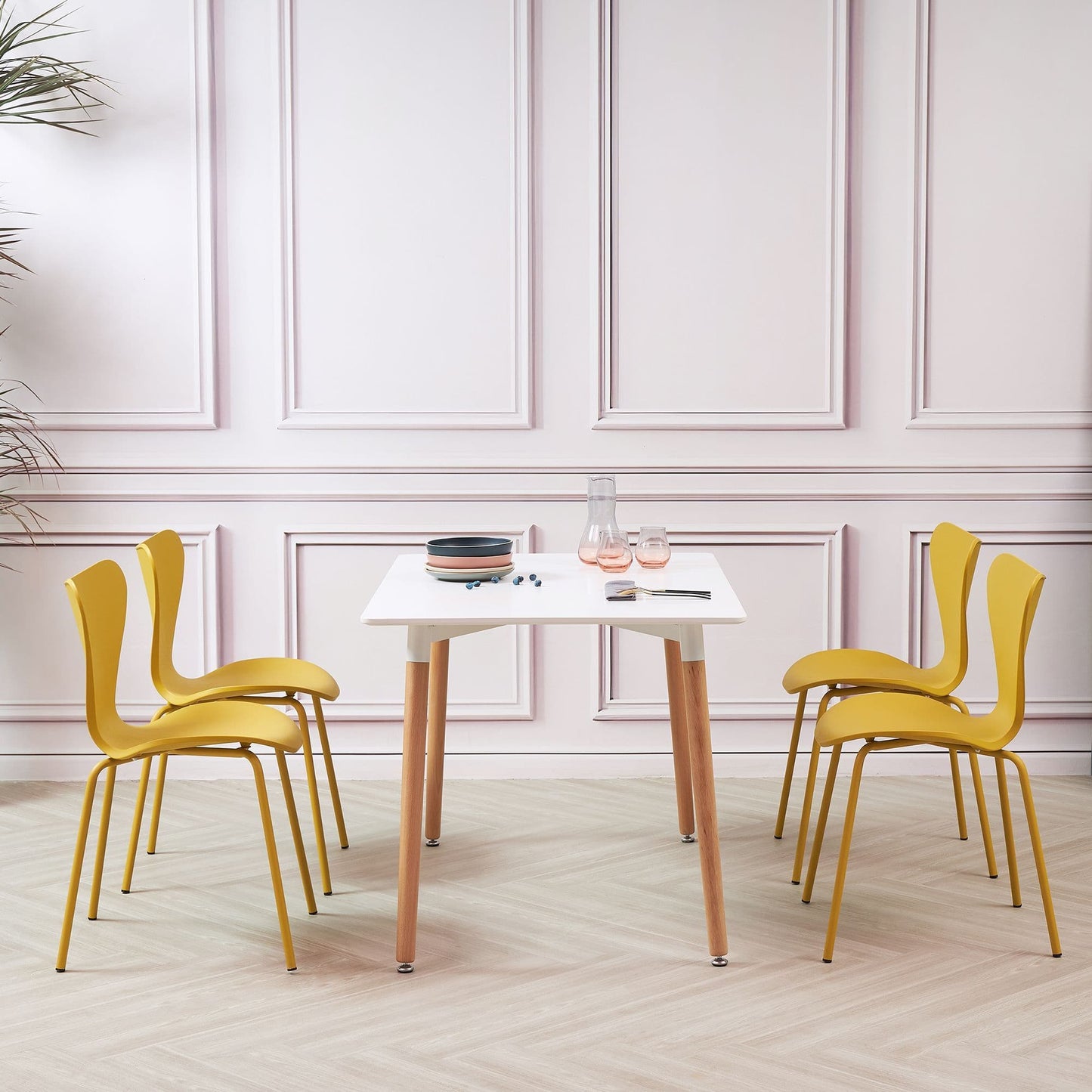 White Rectangular Dining Table with 4 Yellow Stackable Plastic Chairs